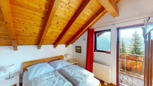a bedroom with a bed and a large window at Tschuggen TU14 in Blatten bei Naters