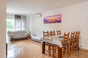 a dining room with a table and chairs and a couch at Villa Florida in Lloret de Mar