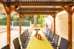 a table with a pineapple and a bowl of fruit on a patio at Villa Florida in Lloret de Mar