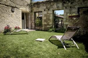 a chair sitting in the grass in a yard at Gîte Rabanier in Saint-Ciers-dʼAbzac
