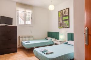 a small room with two beds and a tv at Villa Florida in Lloret de Mar +27 photos
