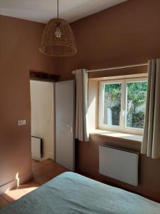 a bedroom with a bed and a window at Gîte Rabanier in Saint-Ciers-dʼAbzac