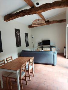 a living room with a table and a couch at Gîte Rabanier in Saint-Ciers-dʼAbzac