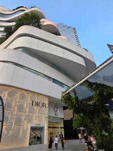 a building with people walking in front of it at Baan Rak BTS phromphong Emsphere in Bangkok