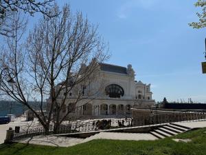 a large building with a fence in front of it at Matei's Apartment by the Sea in Constanţa