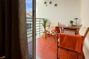 a room with a balcony with a table and chairs at Casa da Rosa by Mth in Porto Santo