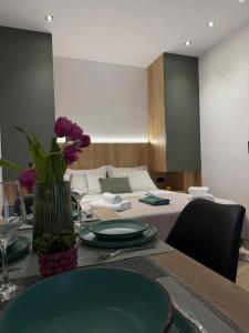 a table with green plates and a vase with purple flowers at Nido Estivo 2 in Nea Skioni +8 photos