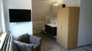 ein Wohnzimmer mit einem TV und einem Stuhl in einem Zimmer in der Unterkunft Ferienhaus Familienglück in Winterberg