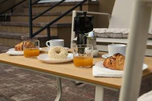 a table topped with plates of bread and orange juice at Netto Apartman in Fonyód