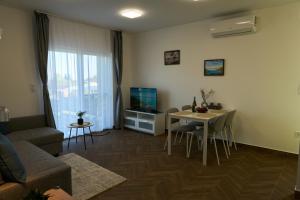 a living room with a couch and a table with a television at Netto Apartman in Fonyód