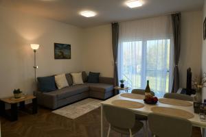 a living room with a couch and a table at Netto Apartman in Fonyód
