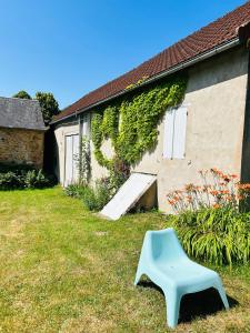 a blue bench sitting in the grass next to a building at La maisonnette du Morvan in Cussy-en-Morvan