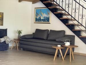 a living room with a couch and a staircase at Bubo House in Črni Kal +8 photos