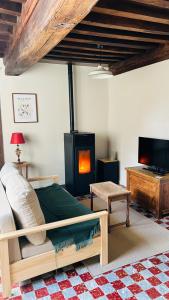 a bedroom with a bed with a fireplace and a tv at La maisonnette du Morvan in Cussy-en-Morvan