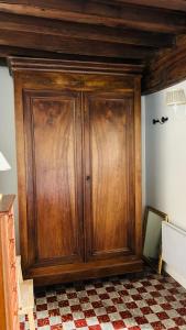a wooden cabinet in a room with a checkered floor at La maisonnette du Morvan in Cussy-en-Morvan