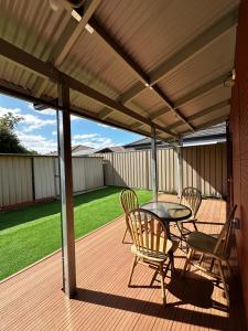 a patio with a table and chairs on a deck at June Stay in Perth