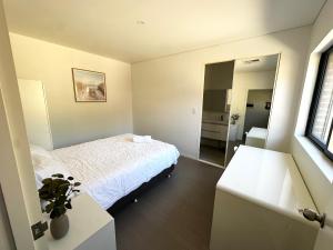 a bedroom with a white bed and a mirror at June Stay in Perth