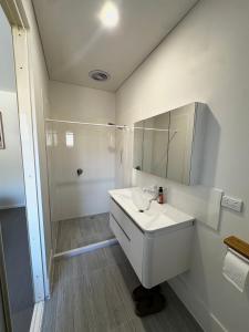 a white bathroom with a sink and a shower at June Stay in Perth +6 photos