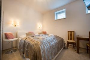 a bedroom with a bed and a desk and two windows at Apartmany U Jezka in Ždiar
