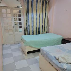 a small room with two beds and a door at OS & MA Luxor in Luxor