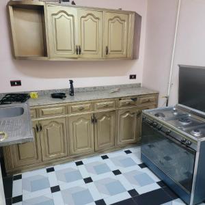 a kitchen with wooden cabinets and a stove at OS & MA Luxor in Luxor