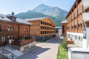 a group of buildings with a mountain in the background at Revier Mountain Lodge Saas-Fee in Saas-Fee