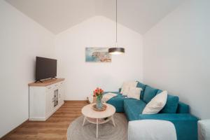 a living room with a blue couch and a table at Domeček U Potoka in České Budějovice