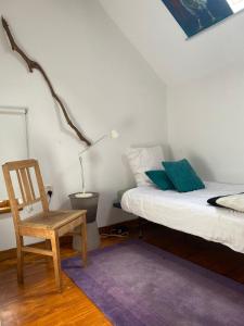 a bedroom with a bed and a chair and a lamp at 't Wirkes in Schimmert