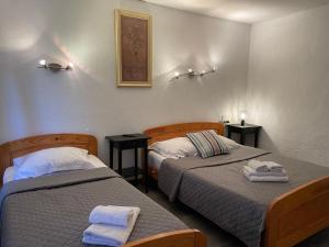 a room with two beds and two towels at Hotel L'Escale in Aigues-Mortes
