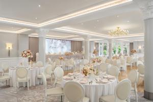 a banquet hall with white tables and chairs at Tullyglass House Hotel in Ballymena