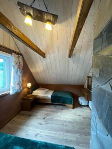 a bedroom with a bed in a attic at Domki BIERWIONO in Cisna +5 photos