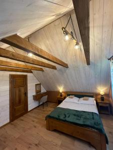 a bedroom with a large bed in a attic at Domki BIERWIONO in Cisna