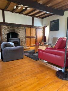 a living room with a red couch and a fireplace at 't Wirkes in Schimmert