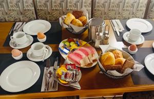 a table topped with plates and bowls of bread and fruit at Gästehaus Tönisvorst in Tönisvorst