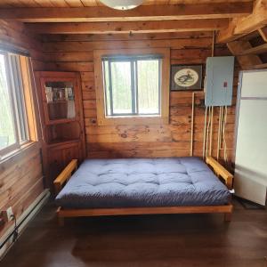 a bed in a log cabin with a window at Pine Hill FLX Retreat in Cohocton