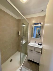 a bathroom with a shower and a sink and a mirror at Hotel L'Escale in Aigues-Mortes +27 photos