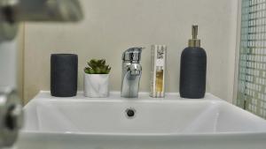 a bathroom sink with a faucet and bottles on it at Apartments St Jakov in Međugorje +48 photos