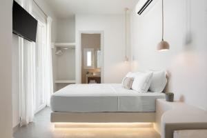 a white bedroom with a bed with white sheets and pillows at Kythea Suites Kythnos in Kithnos +90 photos