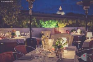 a table in a restaurant with wine bottles and glasses at Orange Hotel in Rome
