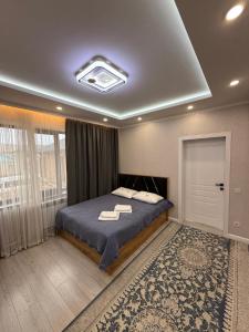 a bedroom with a bed with a blue comforter at Rest House in Bokonbayevo