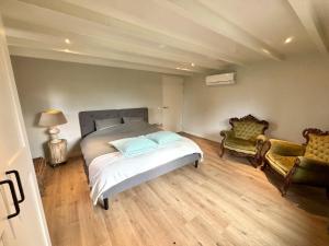 a bedroom with a bed and two chairs at Luxe recreatiebungalows midden in bosrijke omgeving Waalre Noord-Brabant in Waalre
