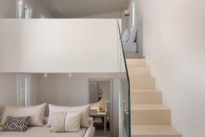 a living room with a couch and a staircase at Kythea Suites Kythnos in Kithnos