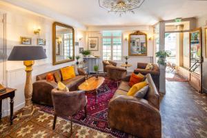 a living room with couches and a table and mirrors at Logis Hotel De France in La Chartre-sur-le-Loir
