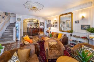 a living room with leather furniture and a mirror at Logis Hotel De France in La Chartre-sur-le-Loir