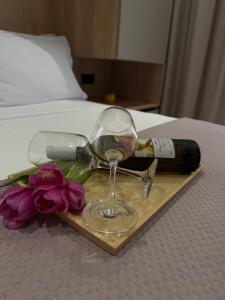 a glass of wine and a bottle and flowers on a tray at Nido Estivo 1 in Nea Skioni