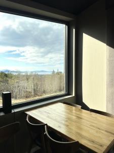 a table and chairs in a room with a large window at Torghatten Lodge in Torget