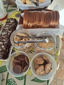 a table topped with bowls of cookies and other pastries at Recanto Ursa Maior in Monte Verde