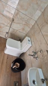 a bathroom with a white toilet and a sink at Grace place in Vagamon