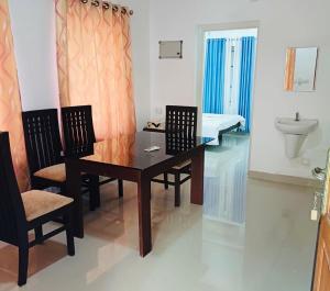 a dining room with a table and chairs and a sink at two bedroom anandha vibes in Guruvāyūr