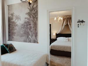 a bedroom with two beds and a painting on the wall at Maison Nº 20 in Eymet